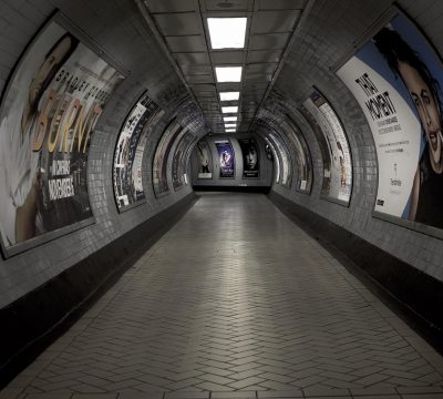 汤不热视频关于页拼贴图之三：地铁站台上一块发光的导视牌，行人匆匆走过，指示箭头清晰